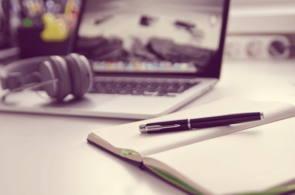 Matériel de bureau pour transcription audio et rédaction professionnelle, incluant ordinateur, casque et agenda