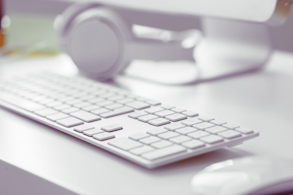 Casque audio posé sur un clavier d'ordinateur, le matériel dont a besoin une transcriptrice audio professionnelle